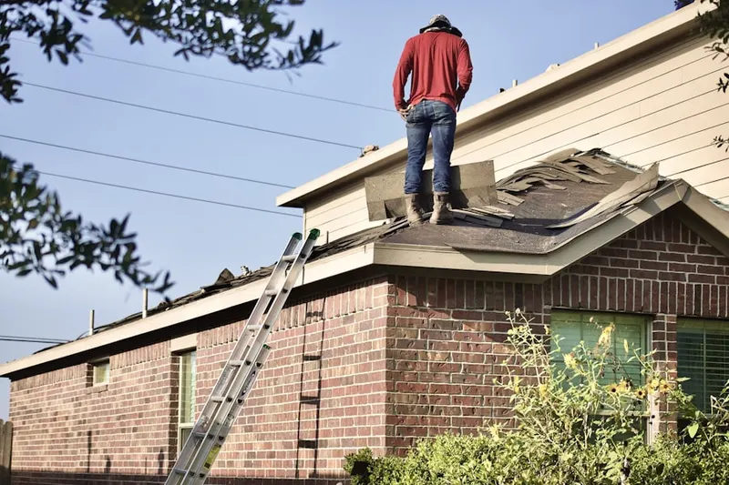 Professional roofer working on a residential roof in Clairmont Park